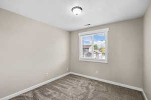 Spare room featuring carpet floors and a textured ceiling