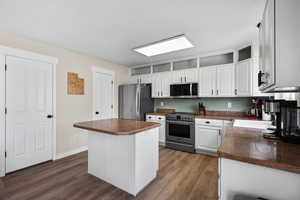 Kitchen with dark countertops, stainless steel appliances, and dark wood finished floors