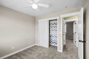 Unfurnished bedroom featuring carpet floors, a closet, and ceiling fan