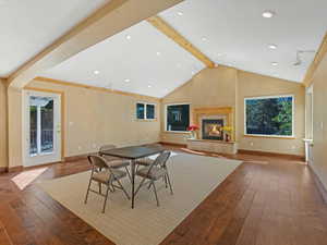 Dining space with hardwood / wood-style floors, a tile fireplace, and recessed lighting