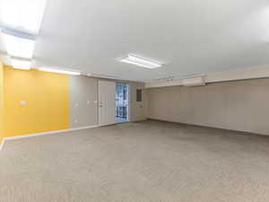 Finished basement with light colored carpet and baseboards