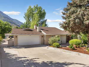 Single story home with driveway, brick siding, a garage, a chimney, and roof with shingles