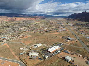 Aerial view of property and surrounding area featuring a mountain backdrop