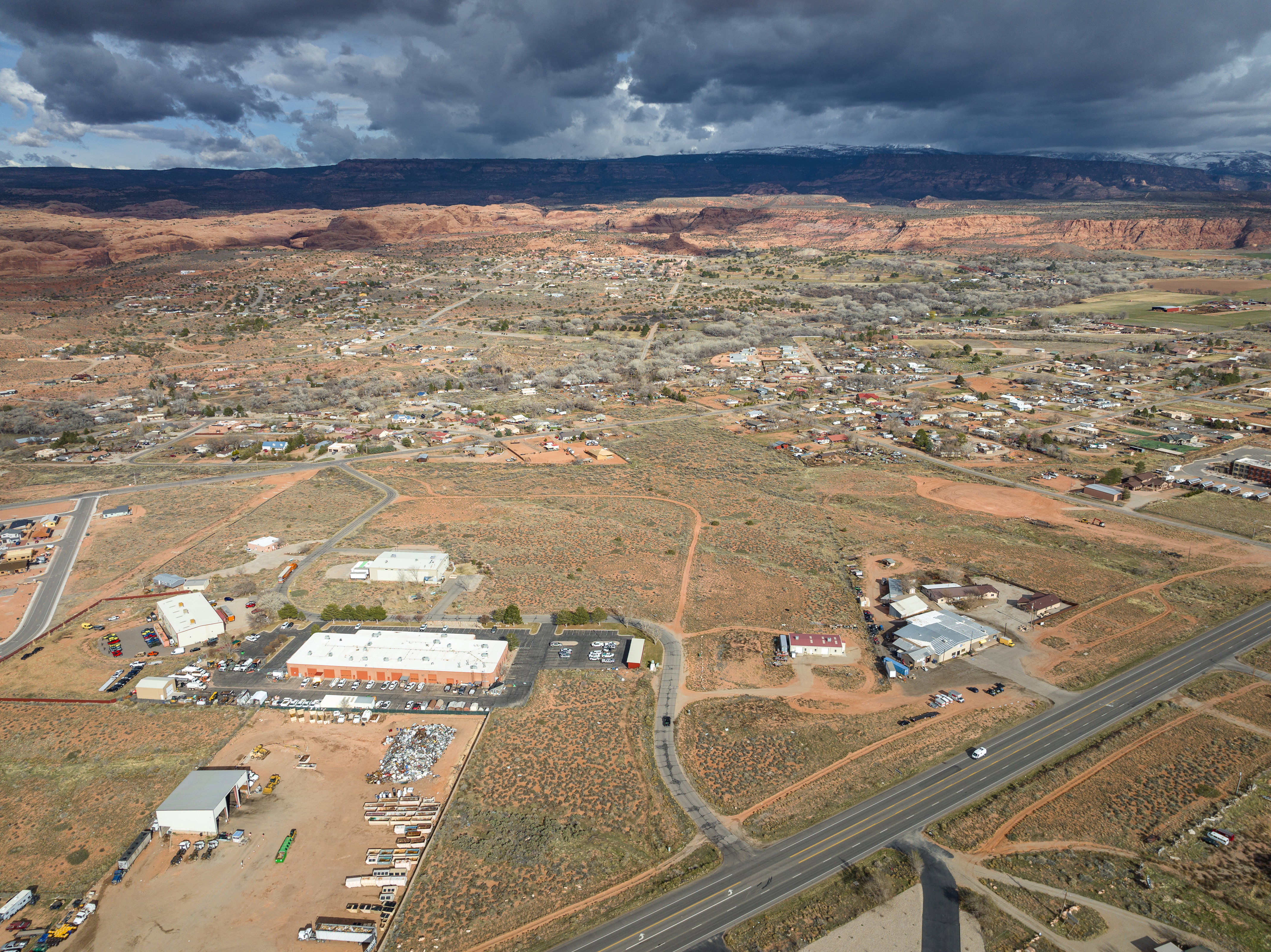 Aerial view of property and surrounding area featuring rural landscape and a mountainous background