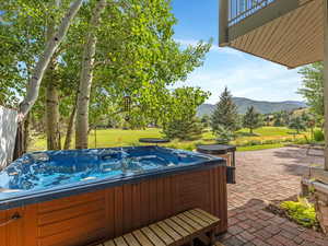 View of patio / terrace with a hot tub and a mountain view