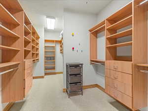 Walk in closet featuring light colored carpet