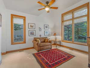 Carpeted living area with healthy amount of natural light and a ceiling fan