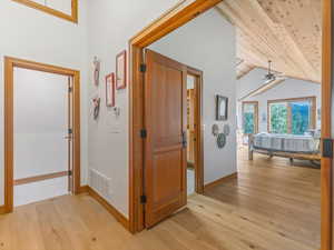 Corridor featuring light wood-style floors and vaulted ceiling