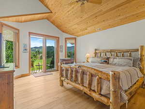 Bedroom with access to exterior, vaulted ceiling, wood ceiling, wood-type flooring, and a mountain view