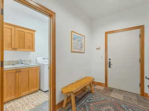 Foyer entrance with washer / dryer and light stone finish flooring