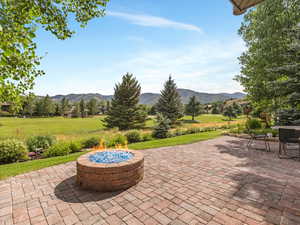 View of patio with a mountain view and a fire pit