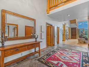 Entrance foyer with a high ceiling and stone tile floors