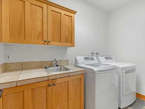 Laundry area featuring cabinet space and independent washer and dryer
