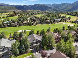 Aerial perspective of suburban area with mountains and a golf club