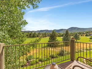 Balcony featuring view of golf course and a mountain view