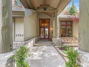 View of exterior entry with french doors, stone siding, and stucco siding