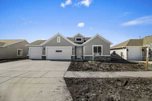 Ranch-style home with stone siding, a garage, concrete driveway, and stucco siding