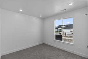 Carpeted spare room featuring baseboards and recessed lighting