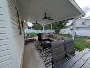 Fenced backyard with an outdoor living space and ceiling fan