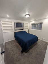 Bedroom featuring a textured ceiling, carpet, and recessed lighting