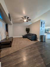 Living area featuring wood finished floors, a ceiling fan, and lofted ceiling