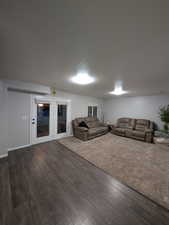 Living room featuring dark wood-type flooring and french doors