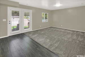 Empty room featuring baseboards and dark wood finished floors