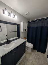 Full bathroom featuring vanity, a shower with curtain, a textured ceiling, and tile patterned floors