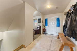 Entryway with arched walkways and a textured ceiling