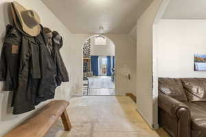Entrance foyer featuring arched walkways and a textured ceiling