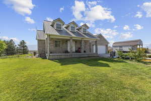 View of front of home with a porch, a metal roof, brick siding, and driveway