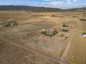 Aerial overview of property's location featuring a mountainous background and rural landscape