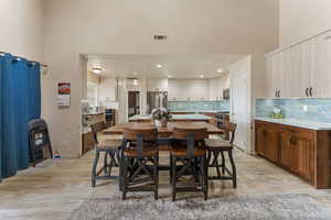 Dining area with a high ceiling and light wood-style flooring