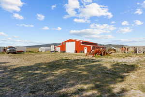 View of yard featuring a detached garage, an outdoor structure, and a mountain view