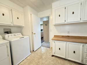 Laundry room with included washer and clothes dryer and extra cabinet space.