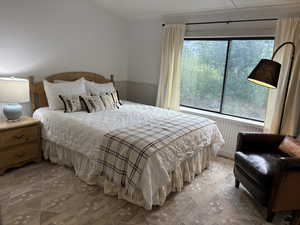 Main floor bedroom with wainscoting, large south facing window and en suite bathroom