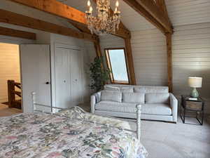 Bedroom featuring wood walls, a chandelier, a closet, carpet flooring, and wooden ceiling