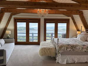 Bedroom featuring access to outside, multiple windows, a water view, wood walls, and wood ceiling