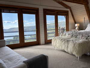 Large primary bedroom upstairs with balcony overlooking a lake