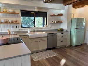 Kitchen featuring open shelves  and stainless steel dishwasher and flat top stove