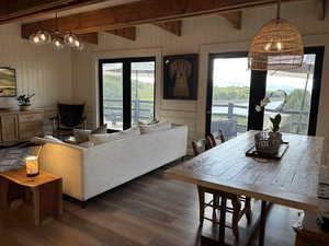 Living room and dining room with access to wrap around deck with view of lake and mountains