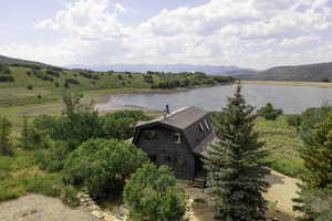 View of subject property with a water and mountain view
