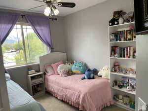 Carpeted bedroom featuring ceiling fan