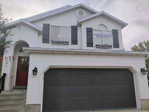 View of front facade featuring a garage and stucco siding