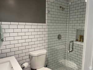 Bathroom featuring a stall shower and tile walls