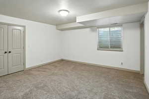Unfurnished bedroom with carpet flooring, a textured ceiling, and a closet