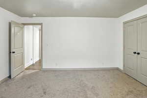 Unfurnished bedroom with carpet and a closet