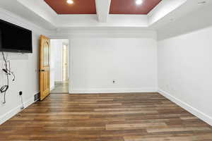 Empty room featuring hardwood / wood-style floors, recessed lighting, a raised ceiling, and ornamental molding