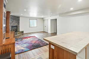 Living room with wood finished floors, a fireplace, and recessed lighting