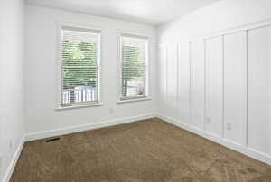 Spare room featuring carpet and baseboards